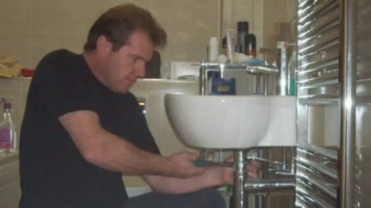 Nigel Whitaker working on a bathroom sink